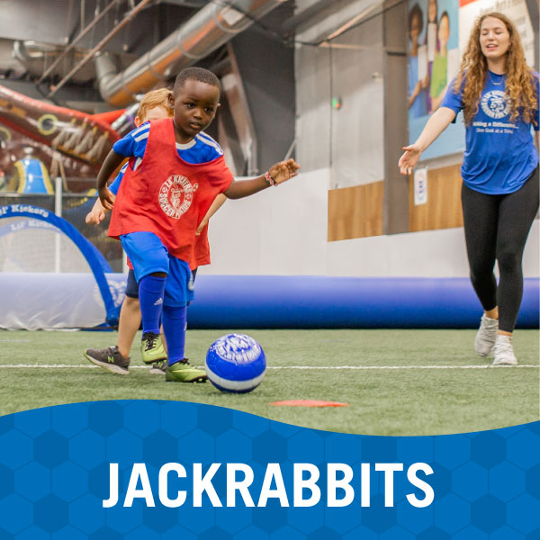 Child and instructor play soccer during Lil' Kickers Jackrabbits class