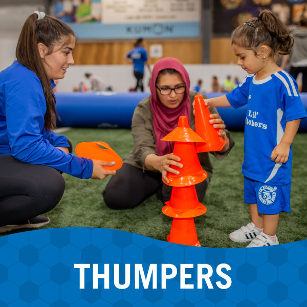 Child and parent play with instructor during Lil' Kickers Thumpers class